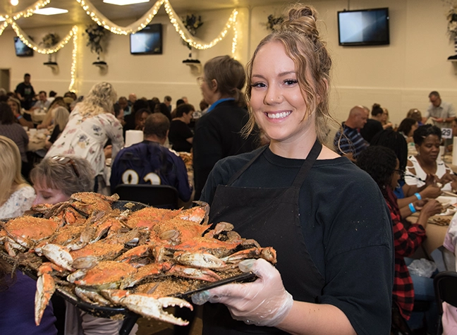 Waitress holding tray of crabs